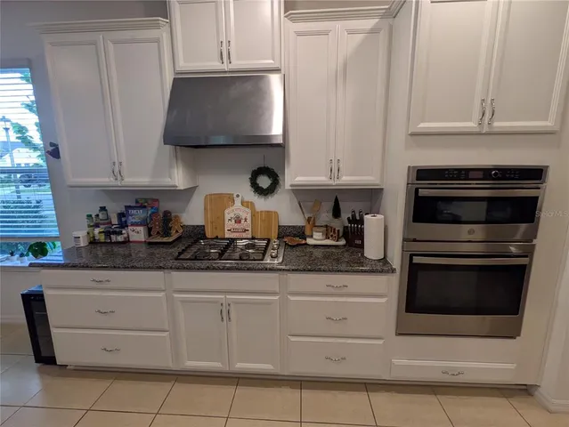 a kitchen with white cabinets and appliances