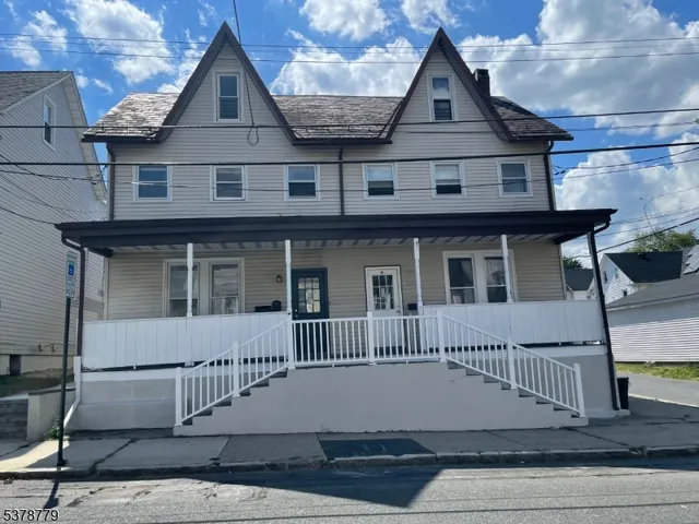 a view of a house with a backyard and wooden fence