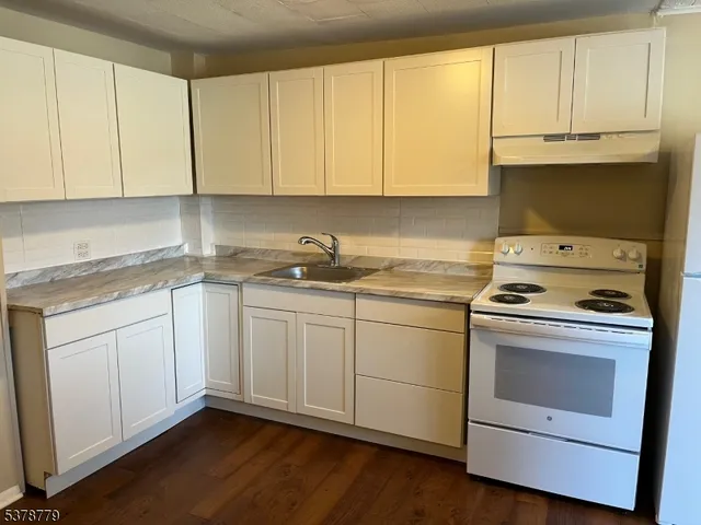 a kitchen with a sink wooden floor and cabinets