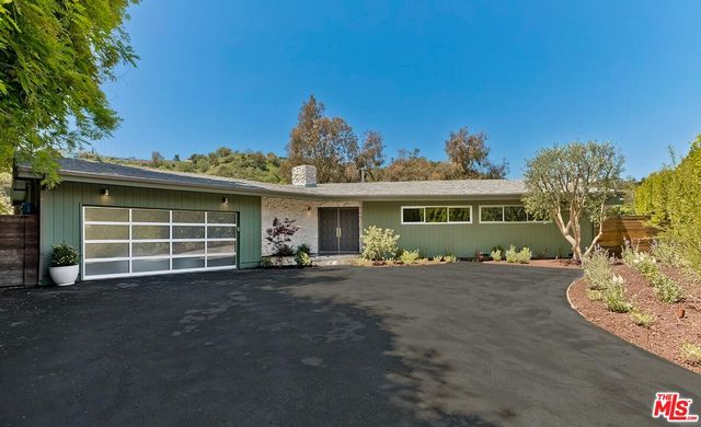 a front view of a house with a garden and porch