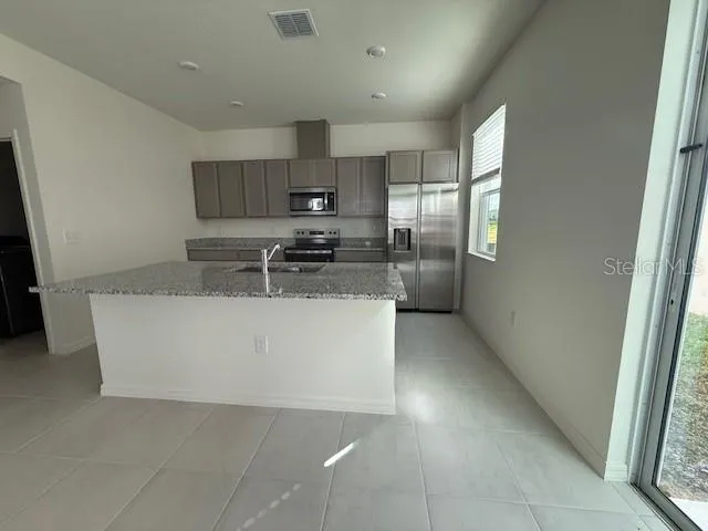 a kitchen with stainless steel appliances a refrigerator sink and microwave