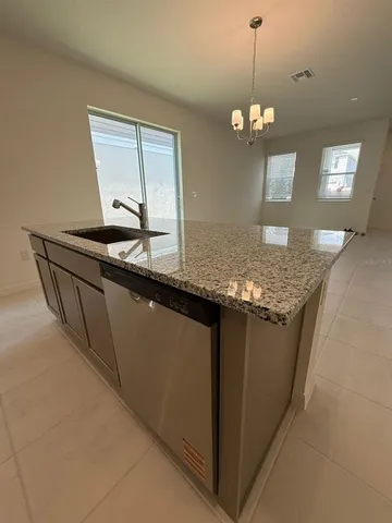 a kitchen with granite countertop cabinets a sink dishwasher and a granite counter top