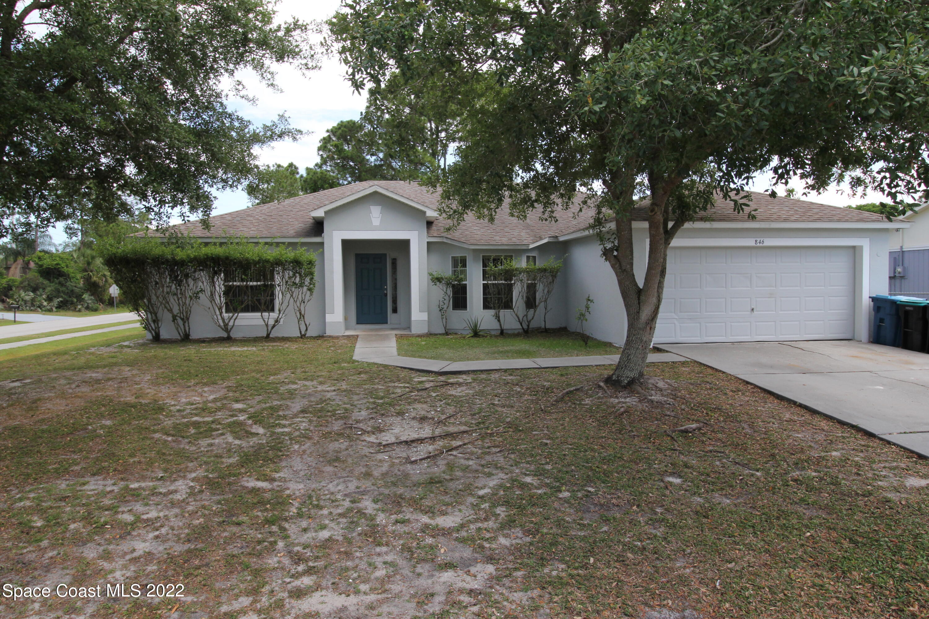 846 Walpole Road Southwest Palm Bay, FL 32908 - Photo 1 of 15 a front view of a house with a yard and trees