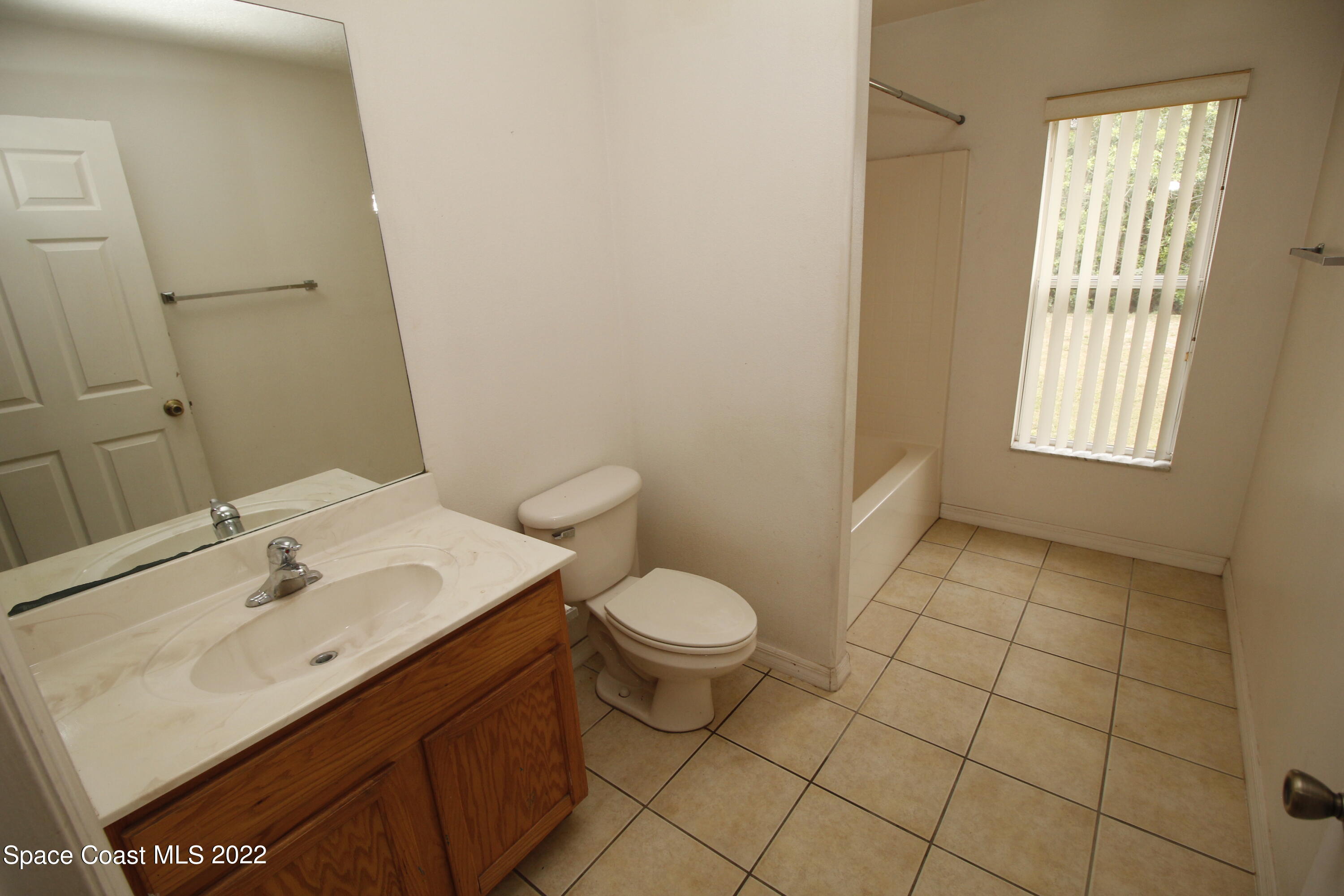 846 Walpole Road Southwest Palm Bay, FL 32908 - Photo 13 of 15 a bathroom with a sink toilet and window