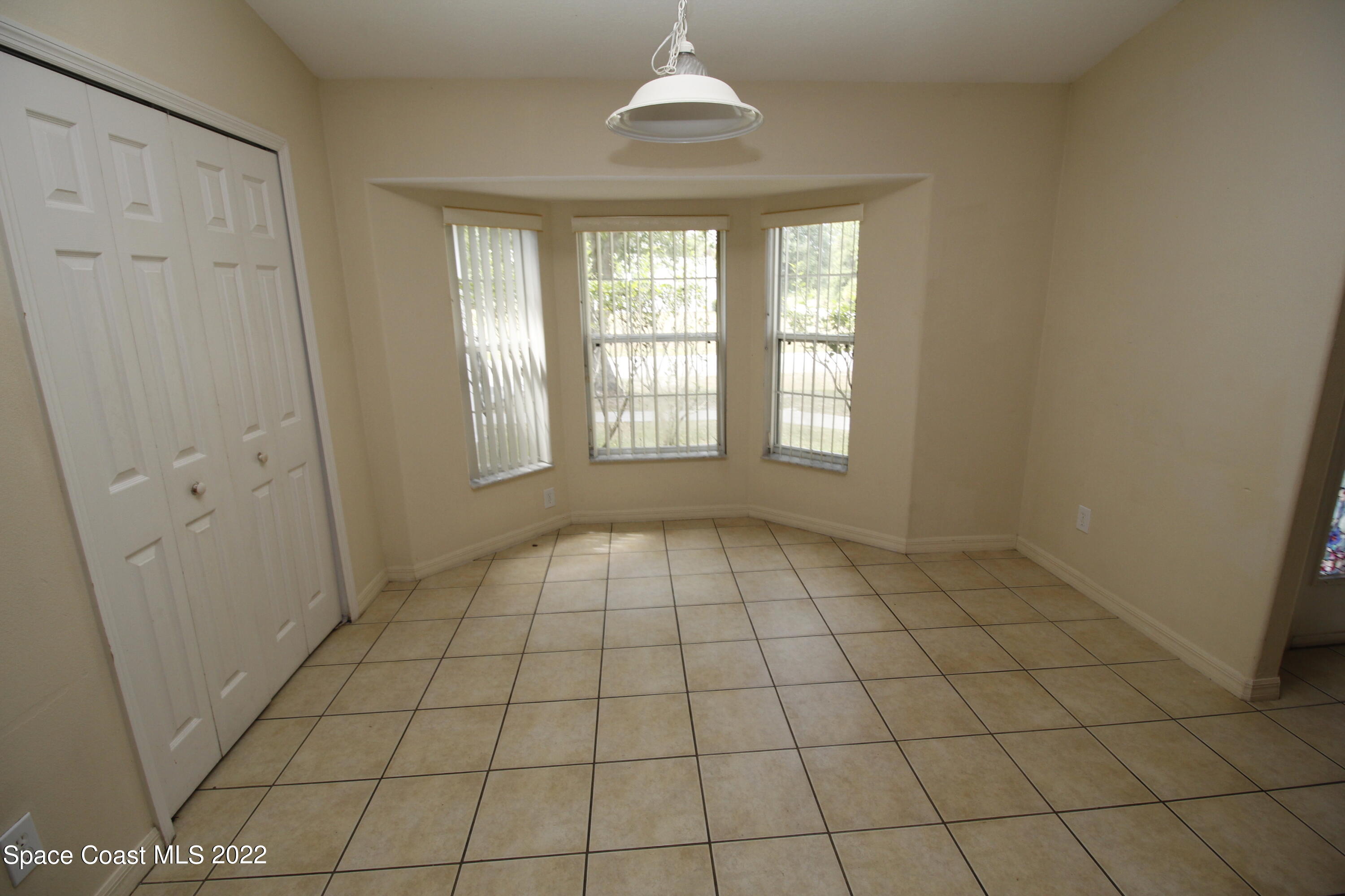 846 Walpole Road Southwest Palm Bay, FL 32908 - Photo 7 of 15 a view of an empty room with window and chandelier fan
