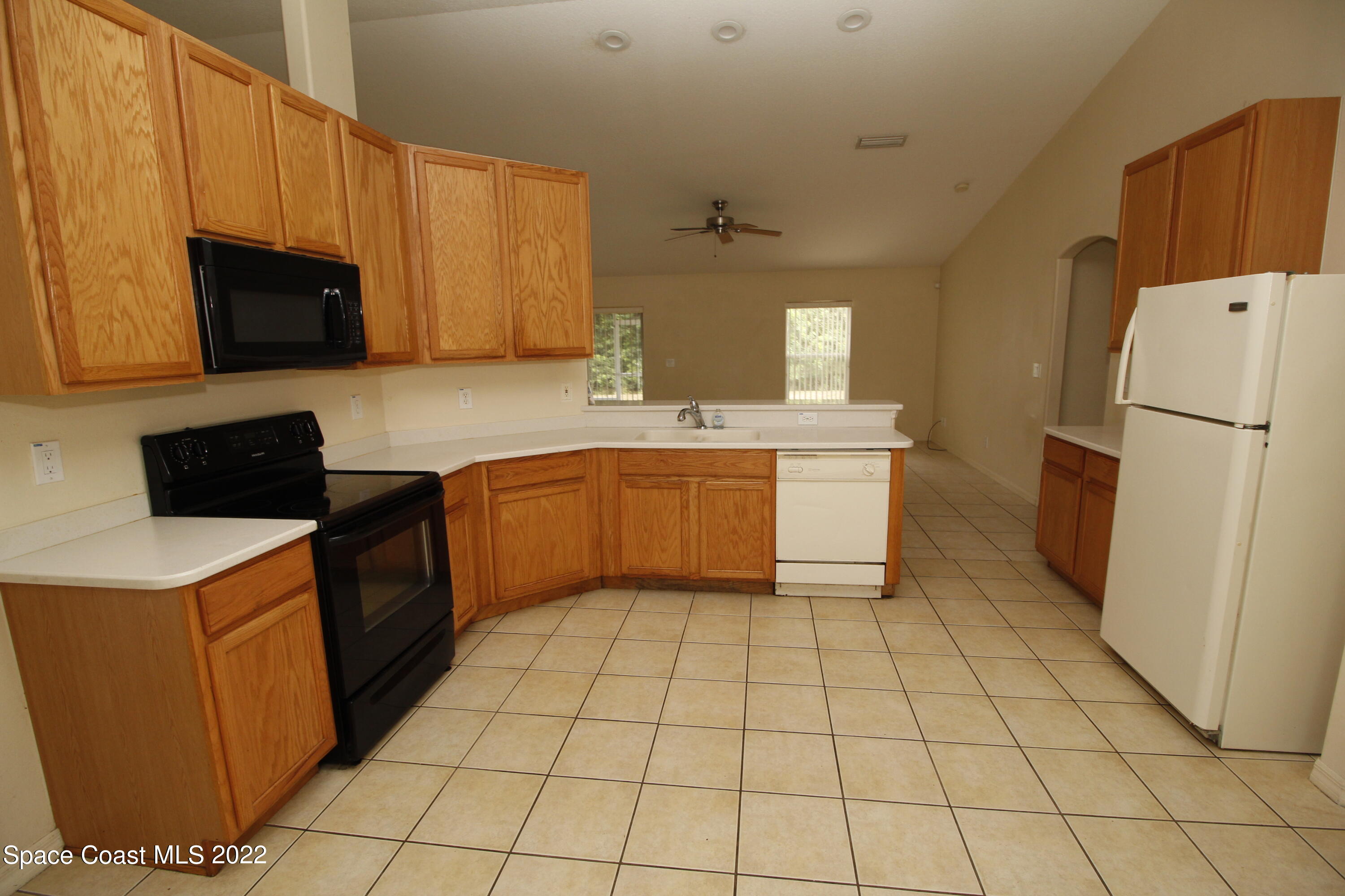 846 Walpole Road Southwest Palm Bay, FL 32908 - Photo 8 of 15 a kitchen with a sink a stove top oven and white cabinets