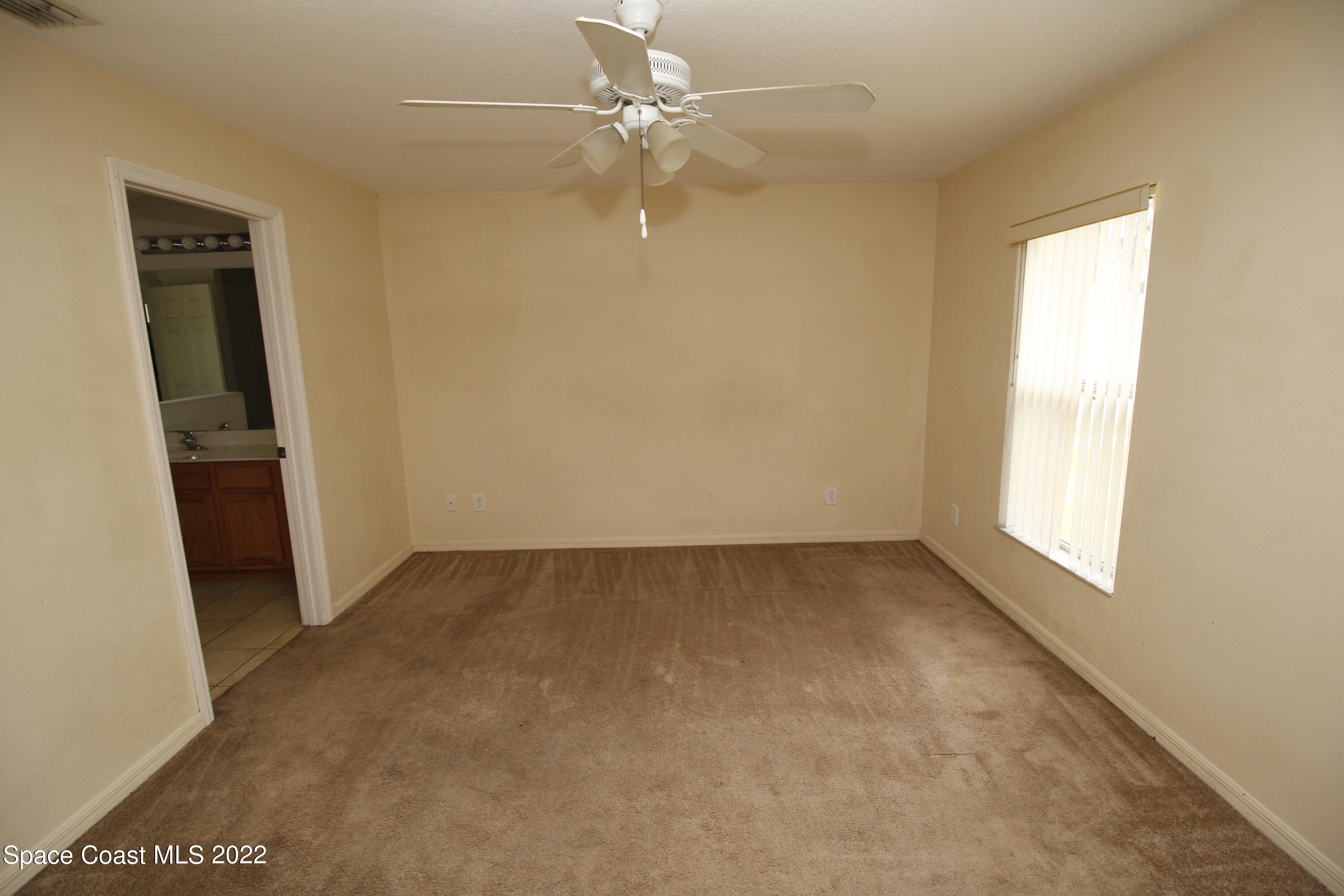 846 Walpole Road Southwest Palm Bay, FL 32908 - Photo 9 of 15 an empty room with windows and fan