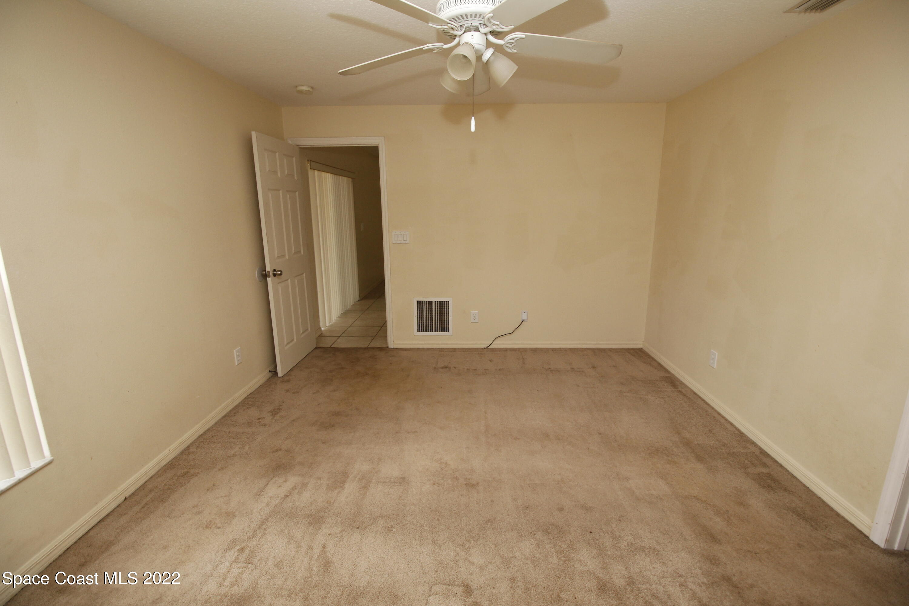 846 Walpole Road Southwest Palm Bay, FL 32908 - Photo 10 of 15 an empty room with a ceiling fan and a window