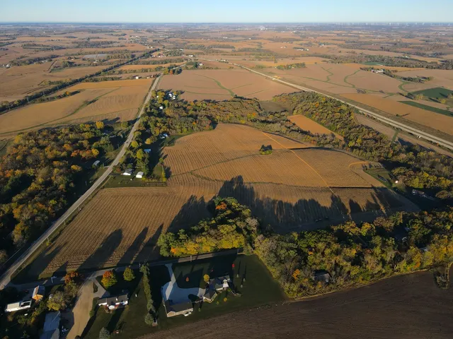 an aerial view of ocean and residential houses with outdoor space