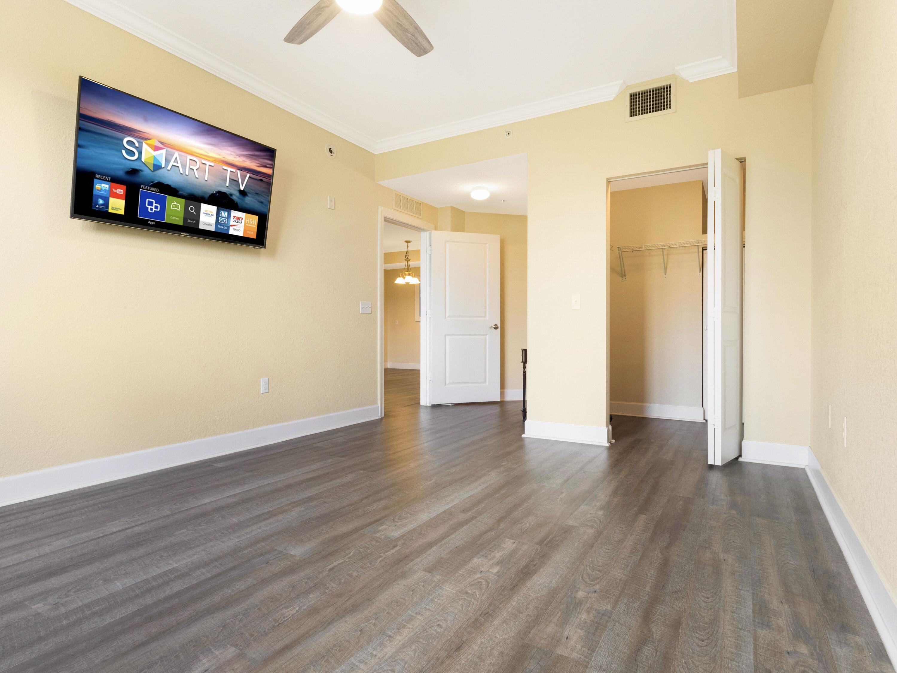 1690 Renaissance Commons Boulevard, Unit 1412 Boynton Beach, FL 33426 - Photo 22 of 49 a view of an empty room with wooden floor and a ceiling fan