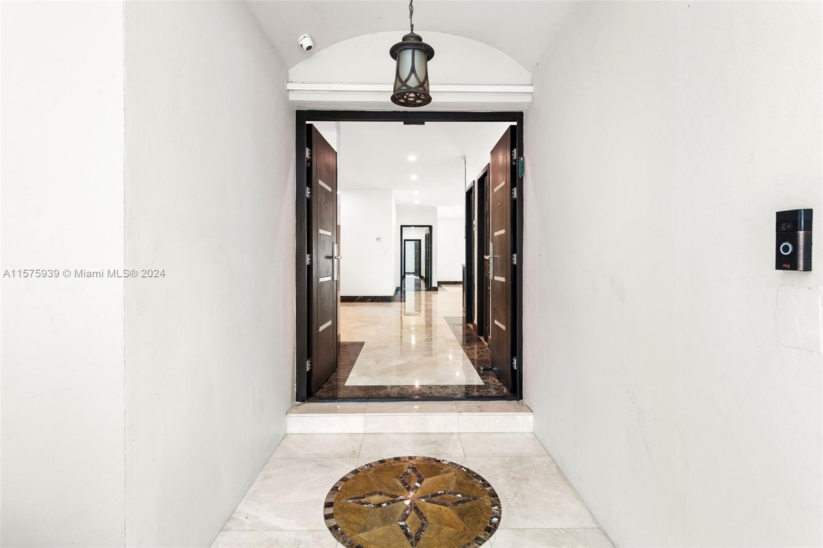 2811 Southwest 22nd Avenue Miami, FL 33133 - Photo 2 of 39 a view of a hallway with a dining table and chandelier
