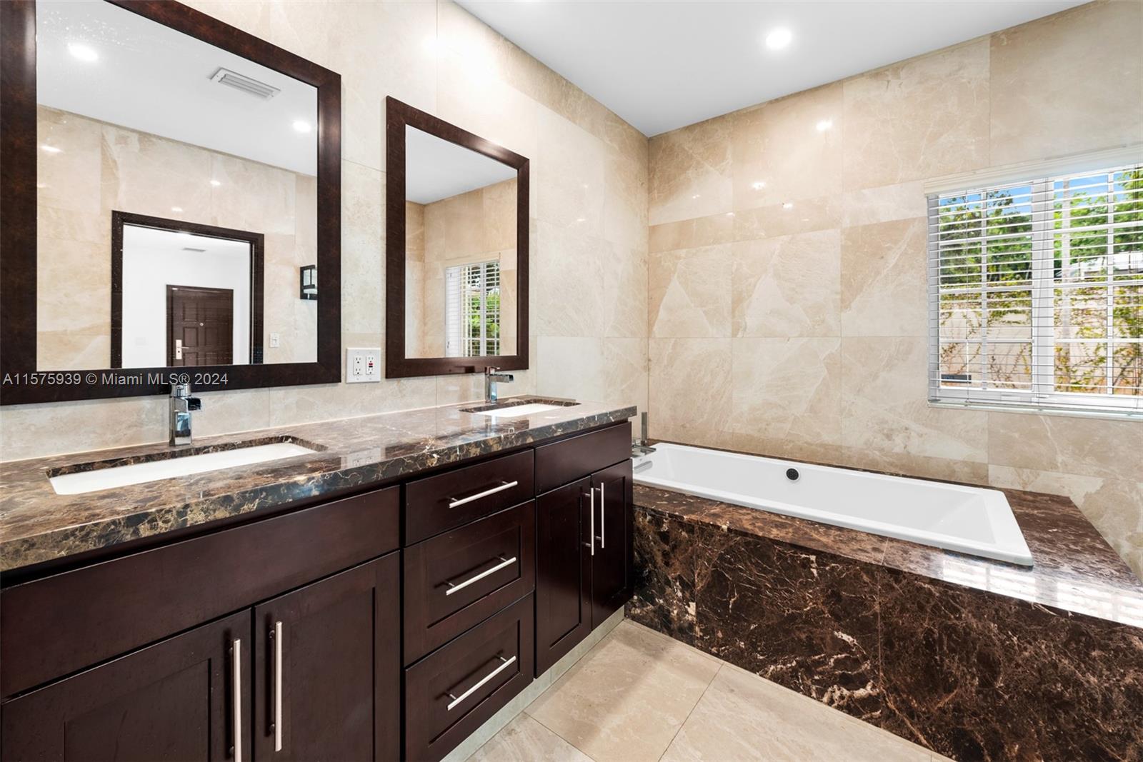 2811 Southwest 22nd Avenue Miami, FL 33133 - Photo 24 of 39 a bathroom with a granite countertop double vanity sink and mirror with bathtub