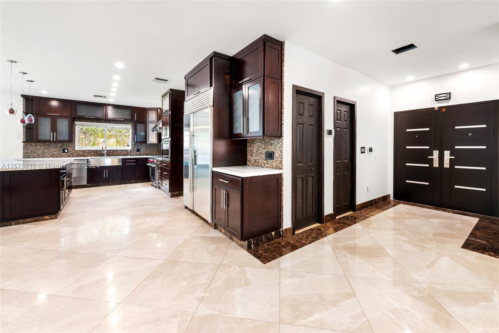 2811 Southwest 22nd Avenue Miami, FL 33133 - Photo 7 of 39 a kitchen with stainless steel appliances kitchen island granite countertop a refrigerator and a stove top oven