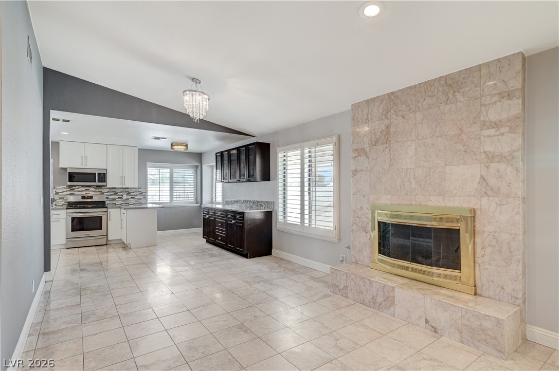 6635 Costa Brava Road Las Vegas, NV 89146 - Photo 9 of 59 A well-lit living area features tiled flooring, a fireplace, and an open-concept kitchen.