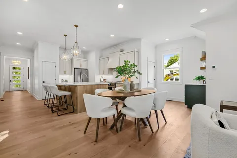 a dining room with furniture a chandelier and wooden floor