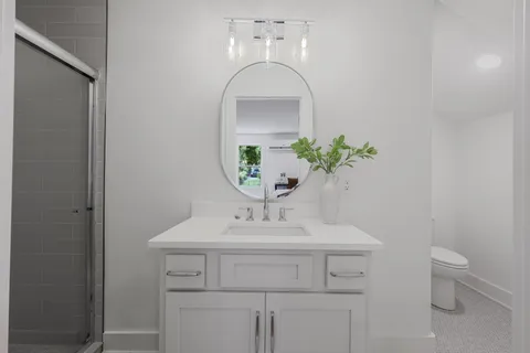 a bathroom with a sink toilet and a mirror
