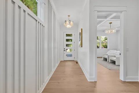 a view of a hallway with wooden floor windows and a livingroom