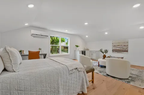 a bedroom with furniture and a large window