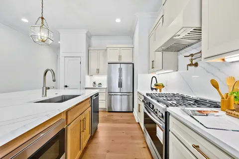 a kitchen with stainless steel appliances granite countertop a sink stove and refrigerator
