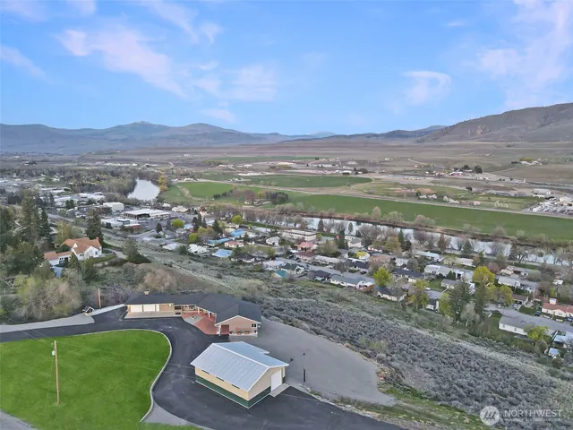 an aerial view of a house with a garden and mountains