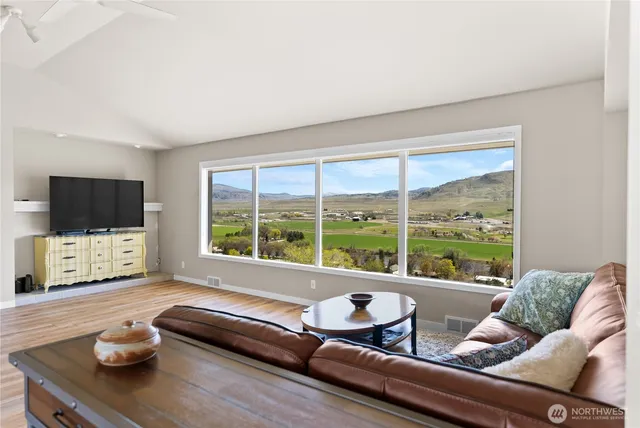a living room with furniture and a flat screen tv next to a large window