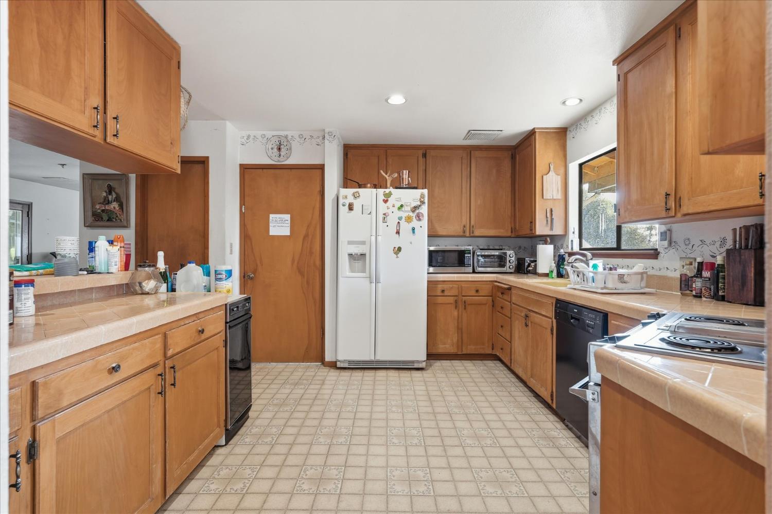 51590 Coyote Ridge Road Oakhurst, CA 93644 - Photo 18 of 49 a kitchen with a refrigerator a sink and cabinets