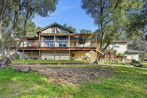 a view of a house next to a yard with big trees