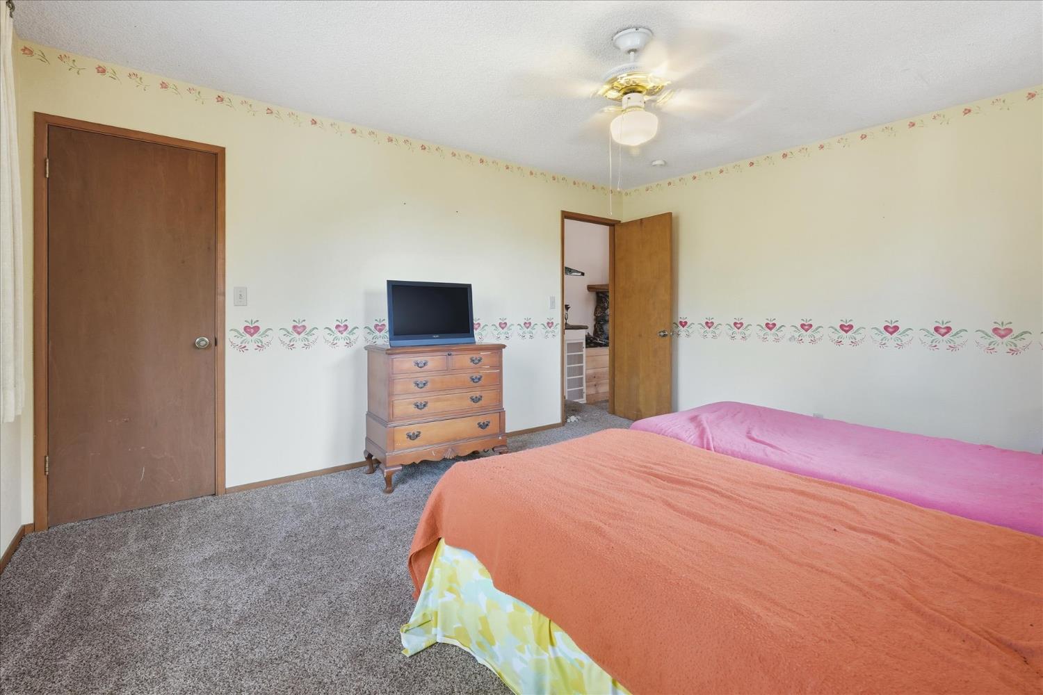 51590 Coyote Ridge Road Oakhurst, CA 93644 - Photo 27 of 49 a bedroom with a bed and a chandelier