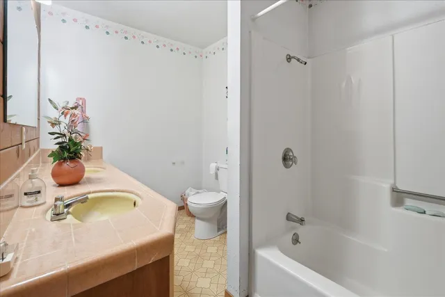 a spacious bedroom with a bed and a chandelier