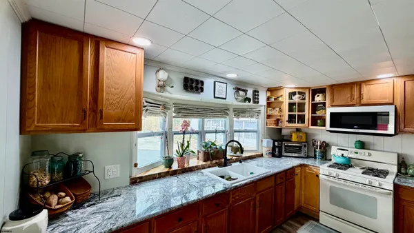 a kitchen with stainless steel appliances granite countertop a stove a sink and a microwave
