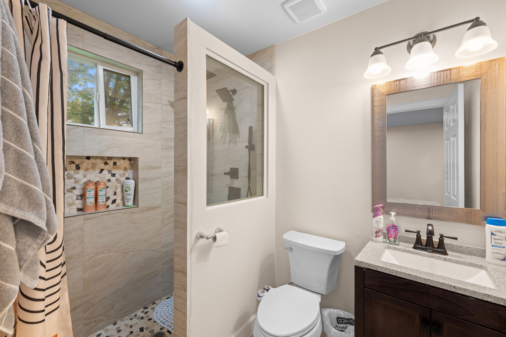 907 East 53rd Street Austin, TX 78751 - Photo 29 of 36 A well-appointed bathroom features a glass-enclosed shower with tiled walls and a modern vanity.