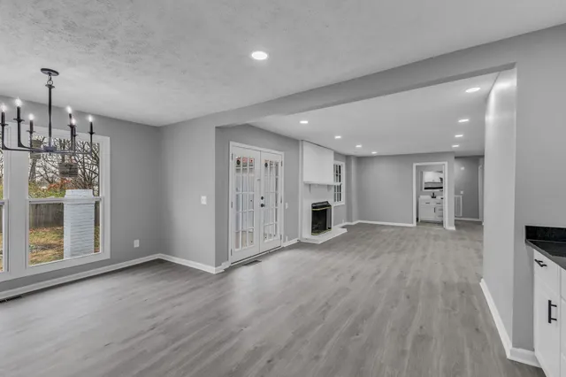 a view of an empty room with wooden floor and closet