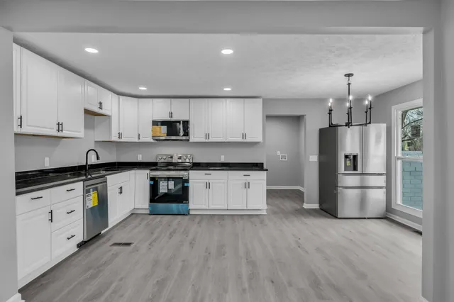 an empty room with wooden floor and window