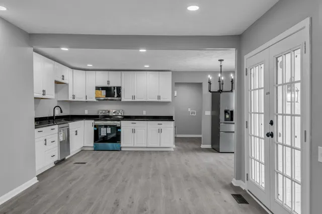an empty room with wooden floor and windows
