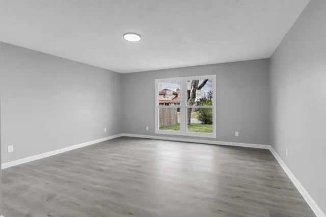 a view of an empty room with wooden floor
