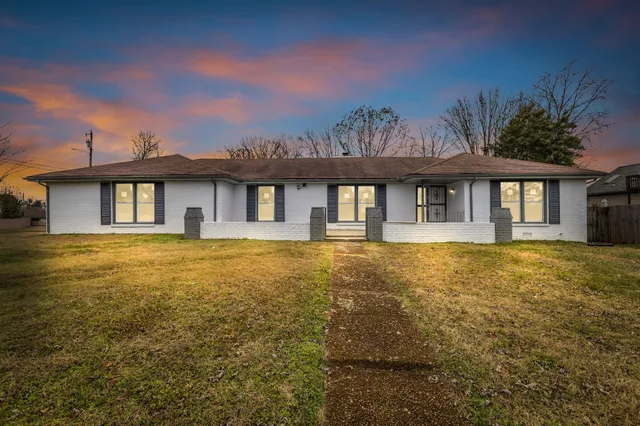 a front view of a house with yard and green space