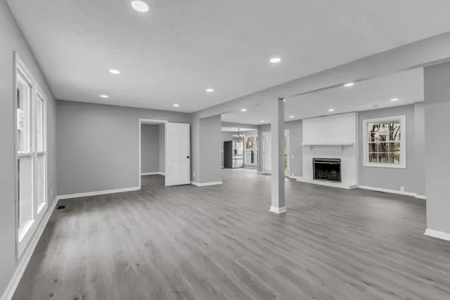 a view of an empty room with a fireplace and a window