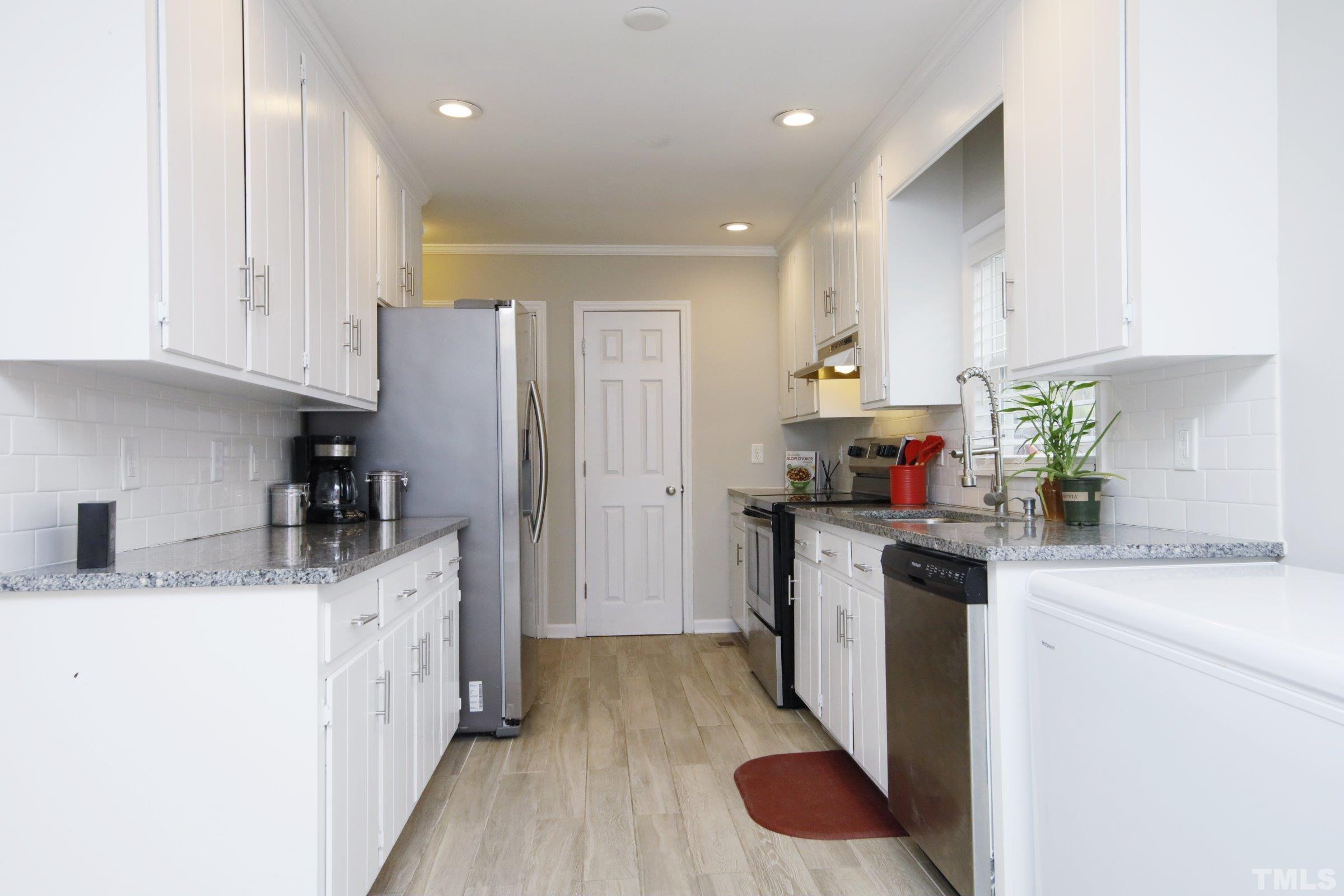 6120 Guess Road Durham, NC 27712 - Photo 6 of 22 a kitchen with stainless steel appliances granite countertop a sink stove and refrigerator