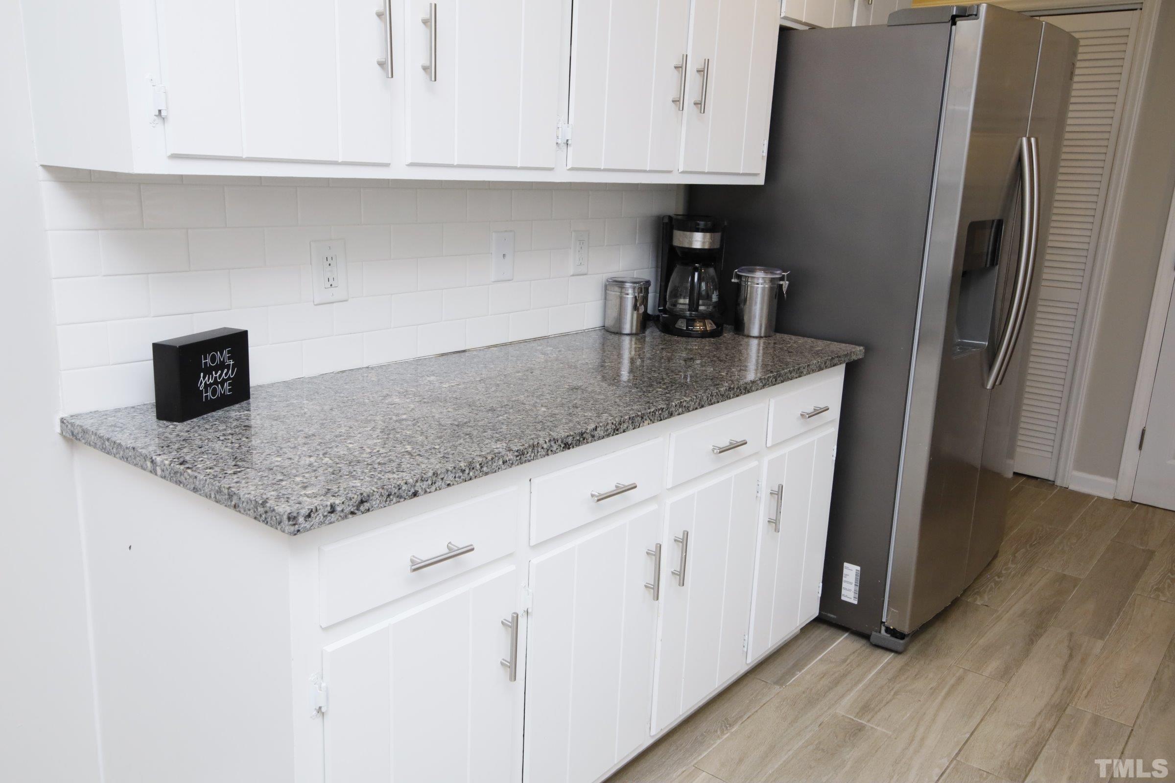 6120 Guess Road Durham, NC 27712 - Photo 8 of 22 a kitchen with granite countertop a sink and a refrigerator