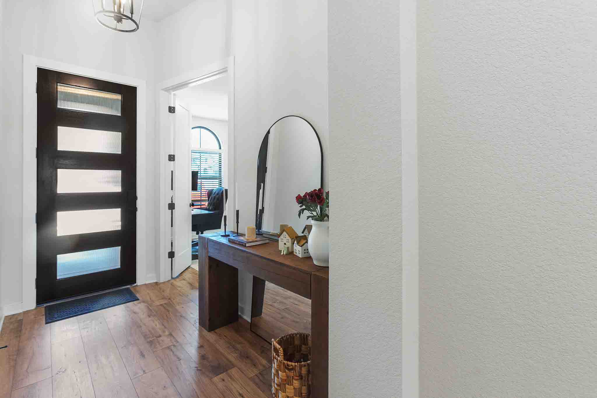 220 Basket Flower Loop Kyle, TX 78640 - Photo 26 of 40 A welcoming entry, with a stylish front door and rich hardwood floors, sets a warm tone.