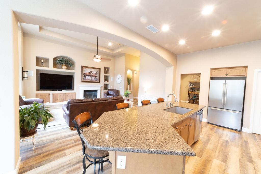 1877 North Coventry Avenue Clovis, CA 93619 - Photo 17 of 61 a living room with stainless steel appliances kitchen island granite countertop furniture and a flat screen tv