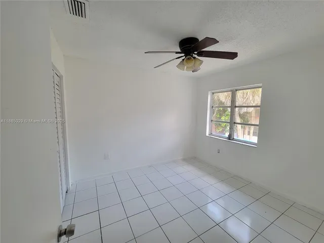 an empty room with fan and windows