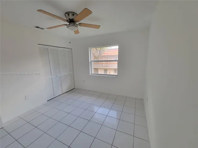 a view of an empty room and chandelier fan