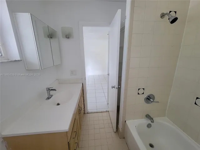 an empty room with windows and ceiling fan