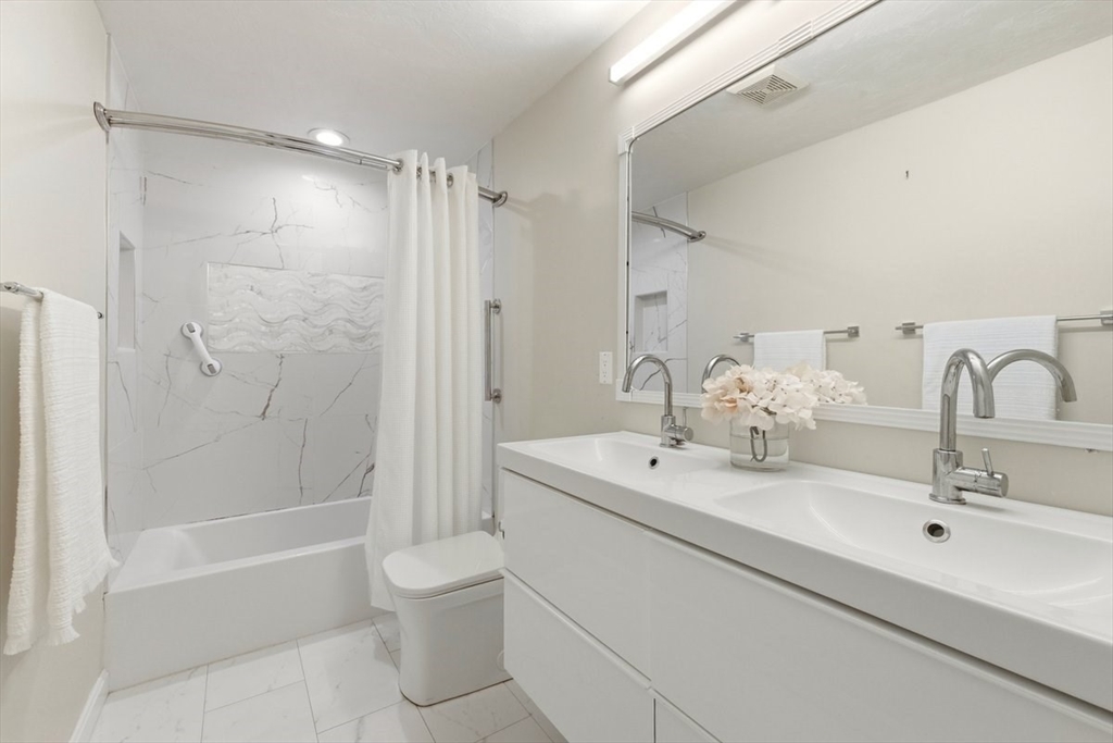 149 Bolivar Street, Unit B2 Canton, MA 02021 - Photo 21 of 34 a bathroom with a double vanity sink toilet mirror and shower