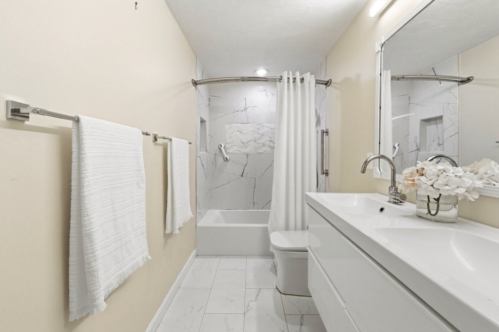 149 Bolivar Street, Unit B2 Canton, MA 02021 - Photo 22 of 34 a bathroom with a bathtub shower sink mirror and toilet