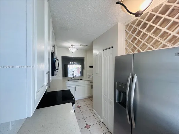 a kitchen with white cabinets and appliances