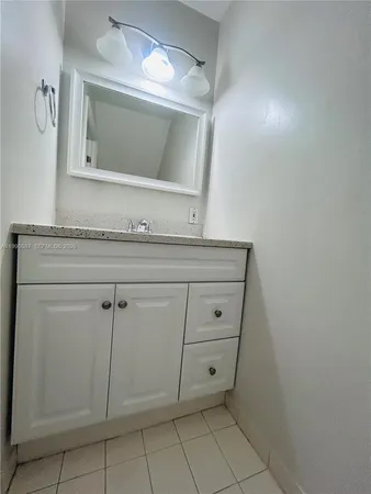 a bathroom with a sink vanity and mirror