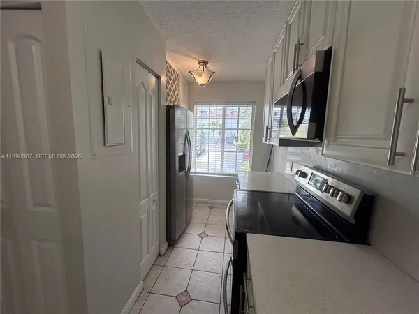 a kitchen with granite countertop a refrigerator and a stove