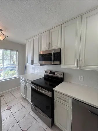 a kitchen with white cabinets and appliances
